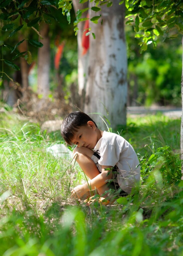 自閉症的非慣性語言行為 獨自蹲坐在樹下的男孩,安靜地望向鏡頭